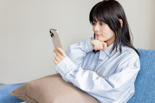 保護者がスマートフォンでクラブの紹介ページを確認している様子